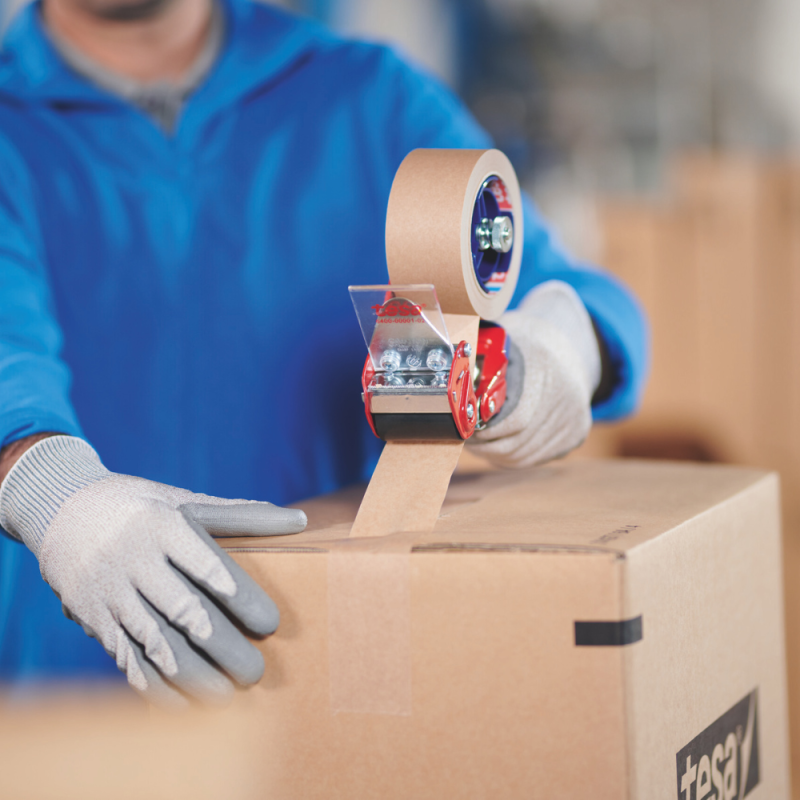 Pracownik zakleja karton taśmą tesa® 4713 – pokaz zastosowania w codziennych operacjach pakowania.