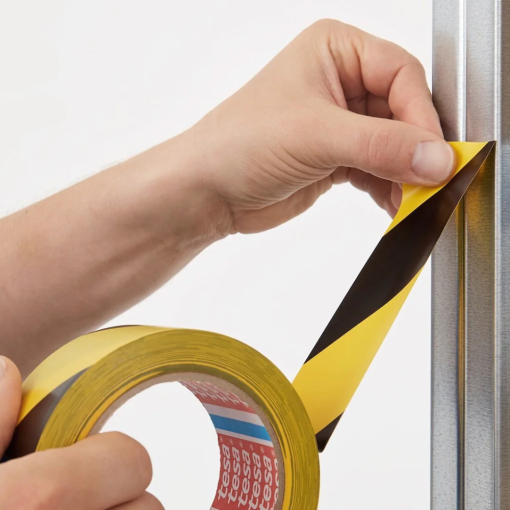 Aplikacja taśmy ostrzegawczej TESA® 60760 żółto-czarnej na elementach konstrukcyjnych.