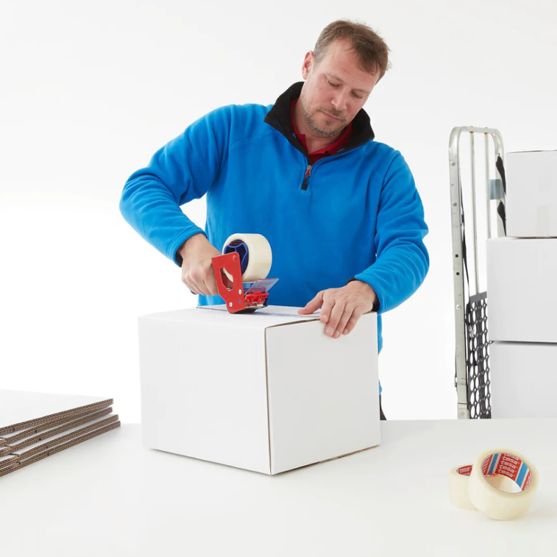 Pracowniczka magazynu używa transparentnej taśmy tesa® 4280 PV0 do zaklejania kartonu do wysyłki.